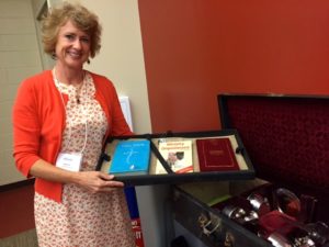 Sharon Stanley-Rea with NFWM's historical communion set during the August 2016 Board meeting